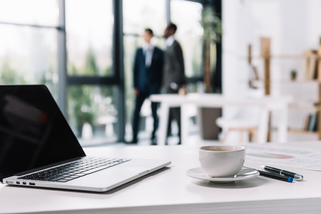 Business workplace with laptop and business colleagues in office